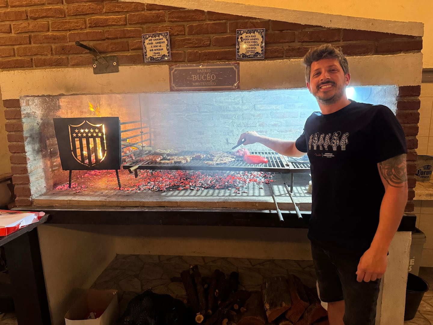 Maxi tending the traditional wood-fired grill at his home in Buceo